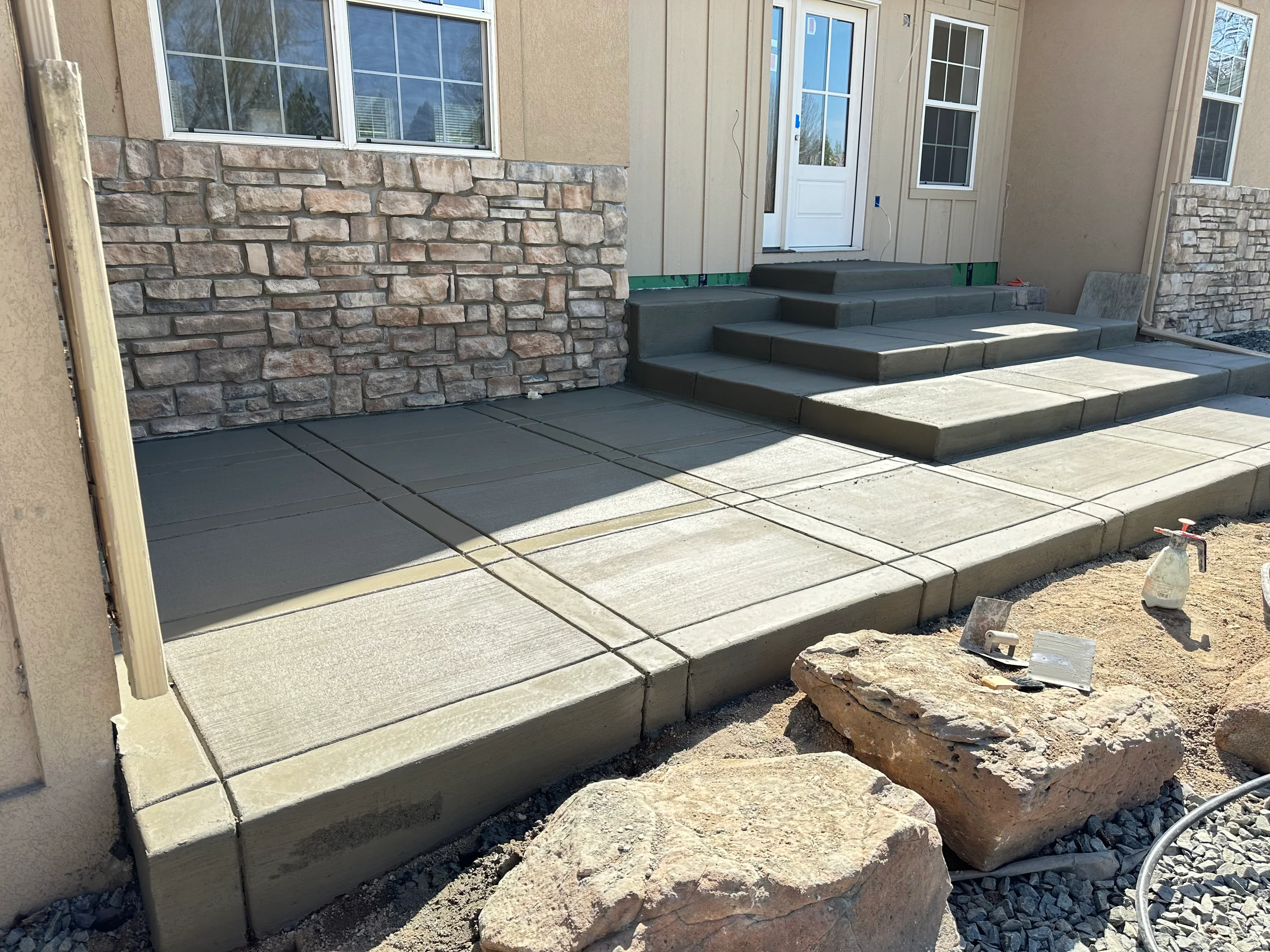 Tiered concrete patio with stacked stone wall and stepped platforms