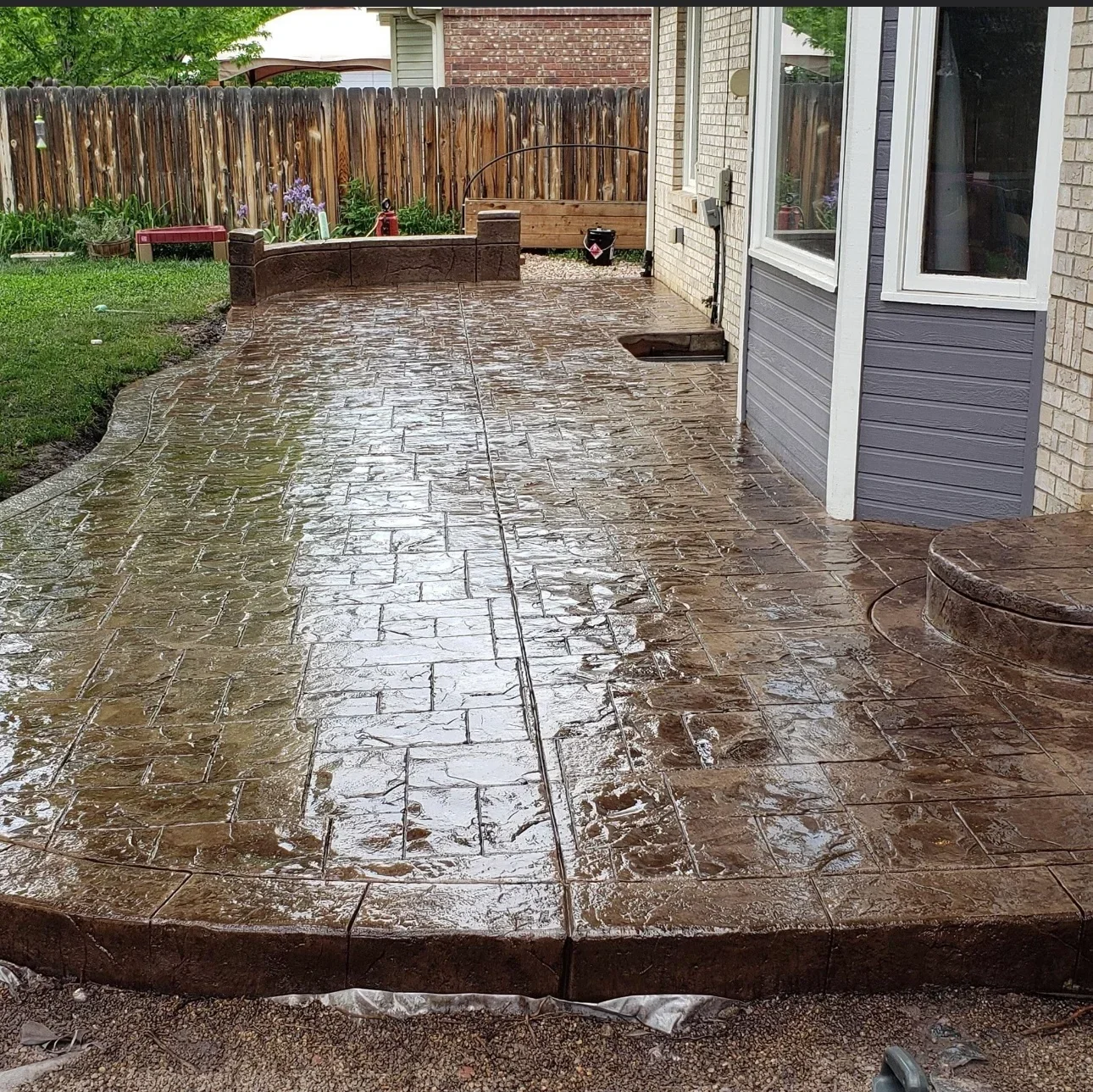 Wet stamped concrete patio with slate pattern and control joints, curved border edge